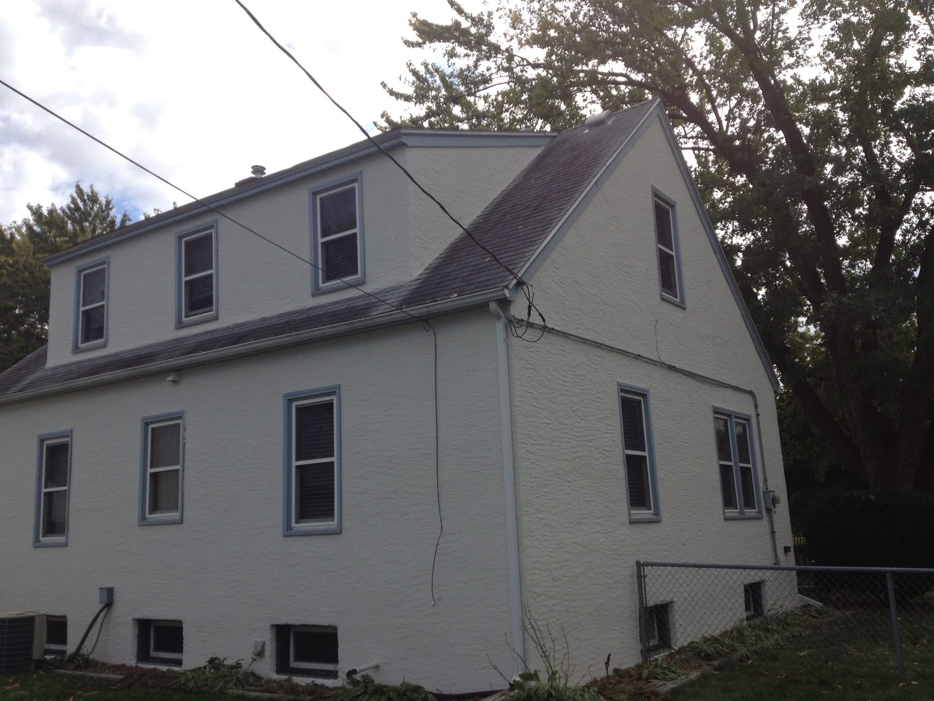 White textured exterior stucco finish on two-story home with gray roof