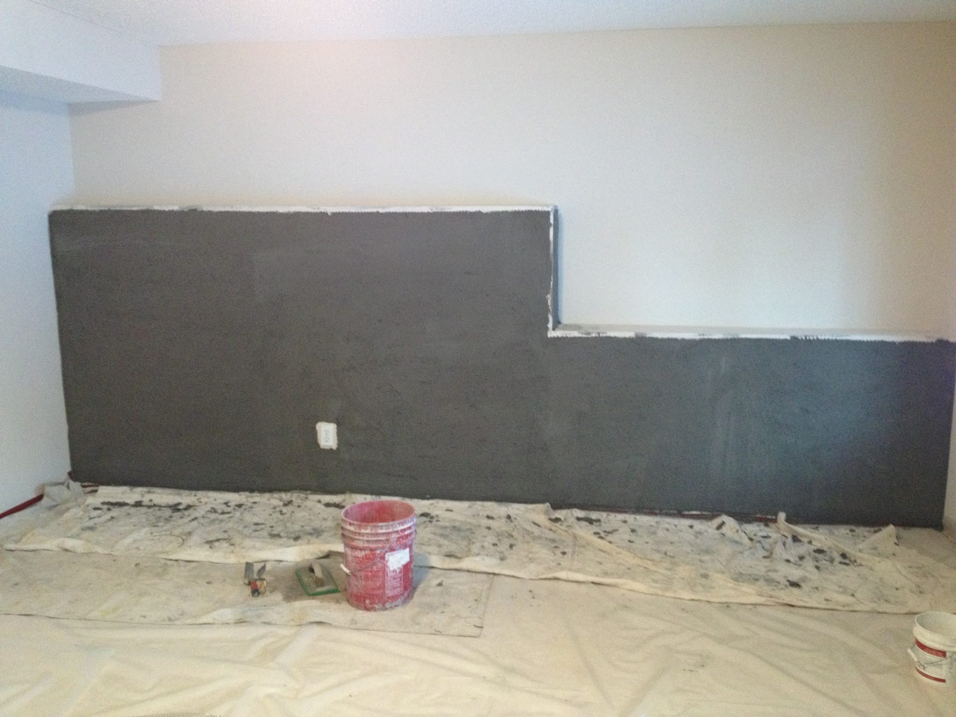 Fresh gray scratch coat plaster applied to interior walls during renovation