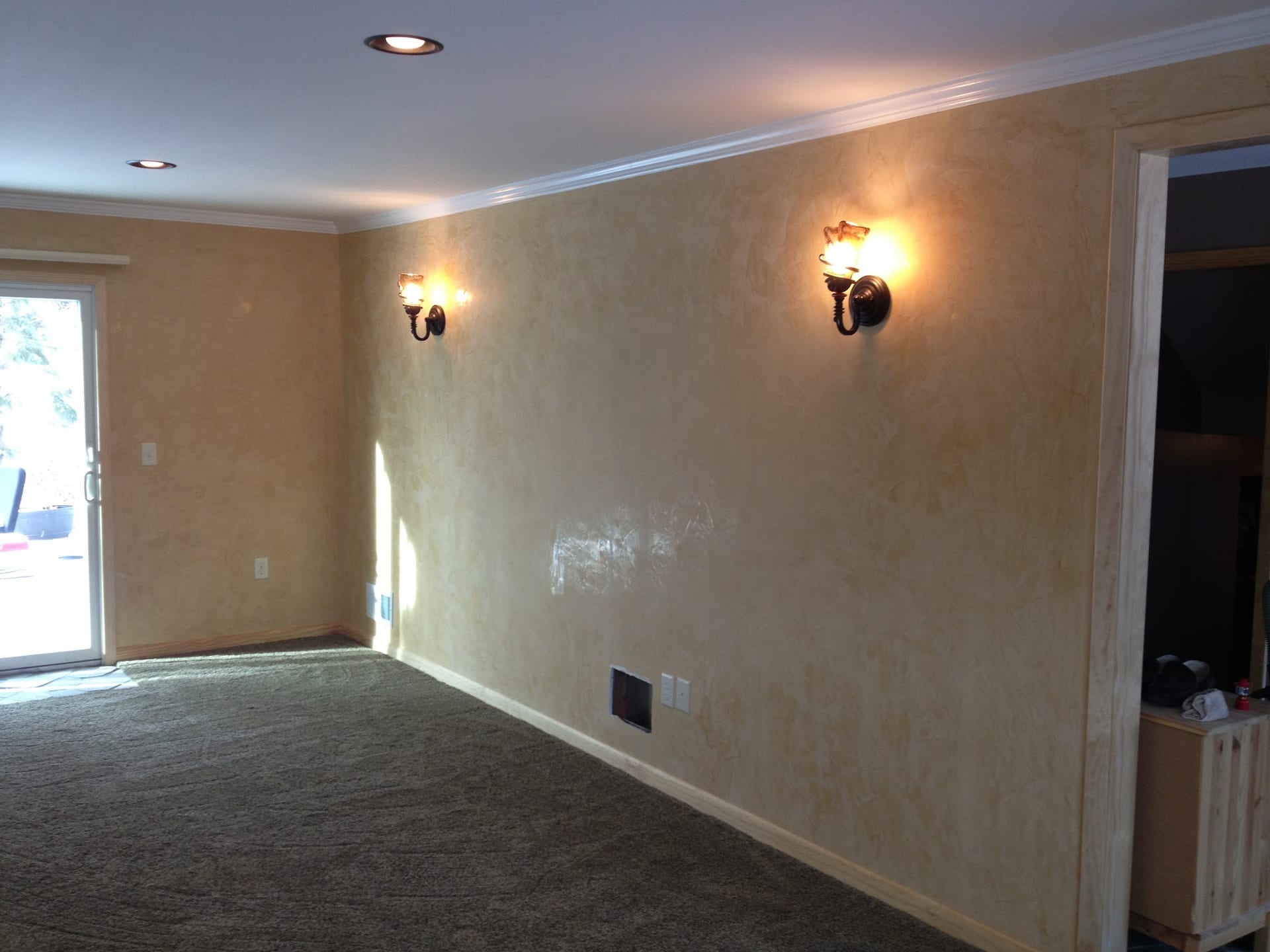 Smooth venetian plaster walls with two bronze wall sconces in empty room