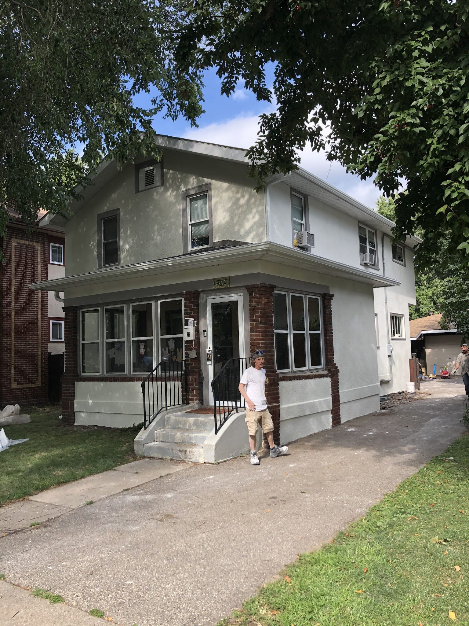 Two-story home with freshly applied exterior stucco and brick accents.