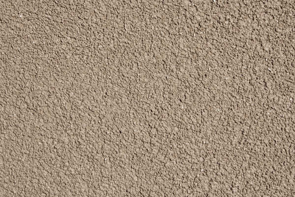 Close-up of a smooth tan granular stucco finish surface